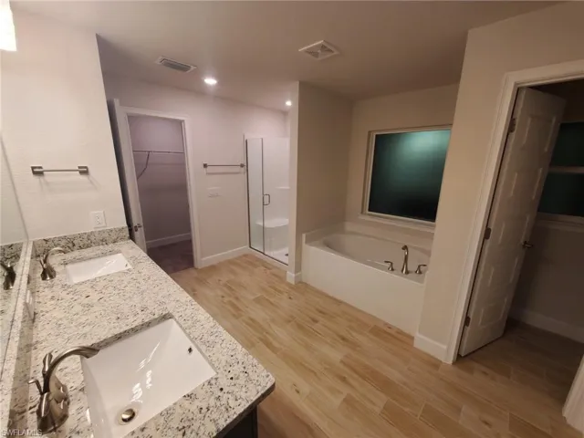 Bathroom featuring hardwood / wood-style flooring, vanity, and independent shower and bath