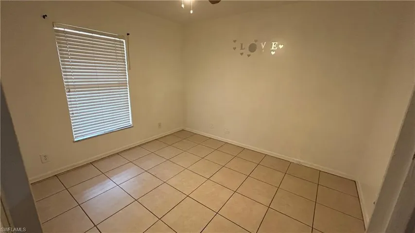 Tiled empty room featuring ceiling fan