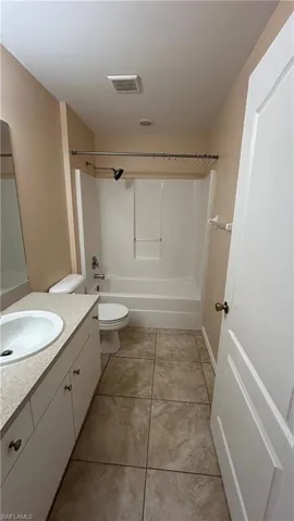 Full bathroom featuring vanity, toilet, tile patterned floors, and  shower combination