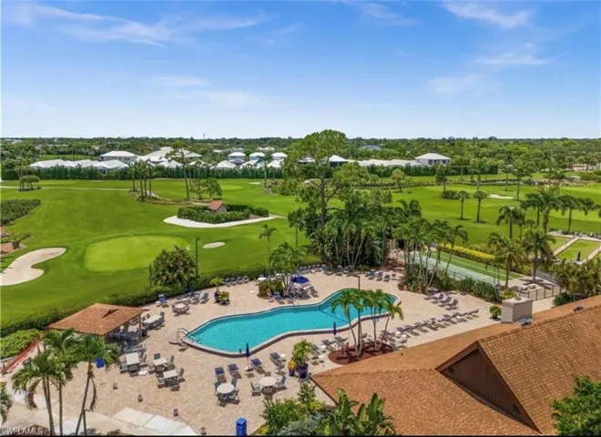 Community pool with golf course view and a patio