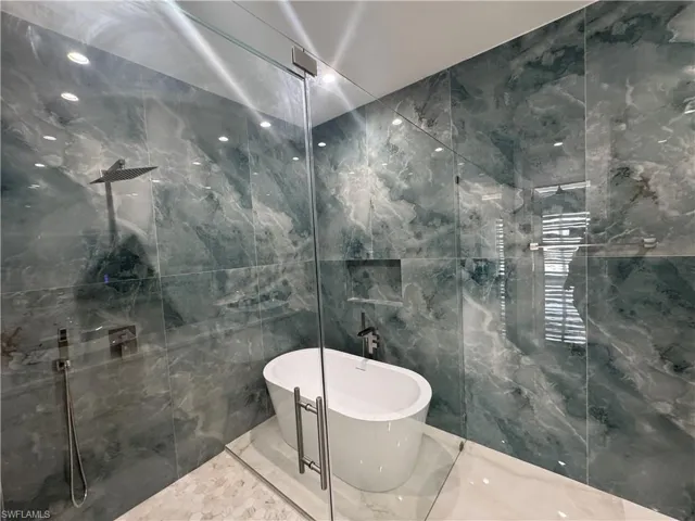 Bathroom with tile walls and plus walk in shower