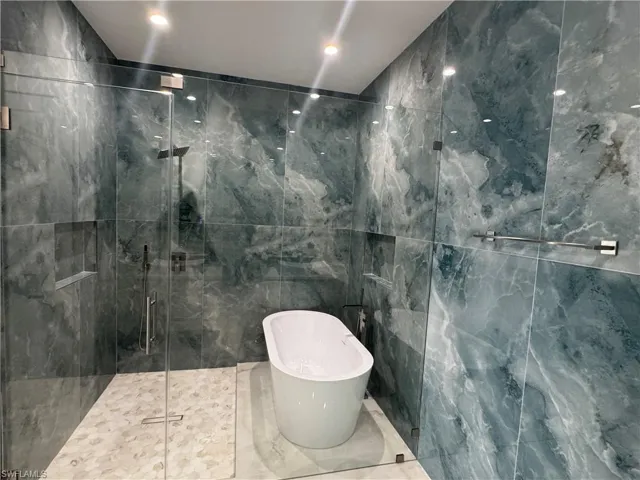 Bathroom with tile walls and shower with separate bathtub