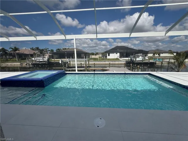 View of swimming pool with a water view and a lanai