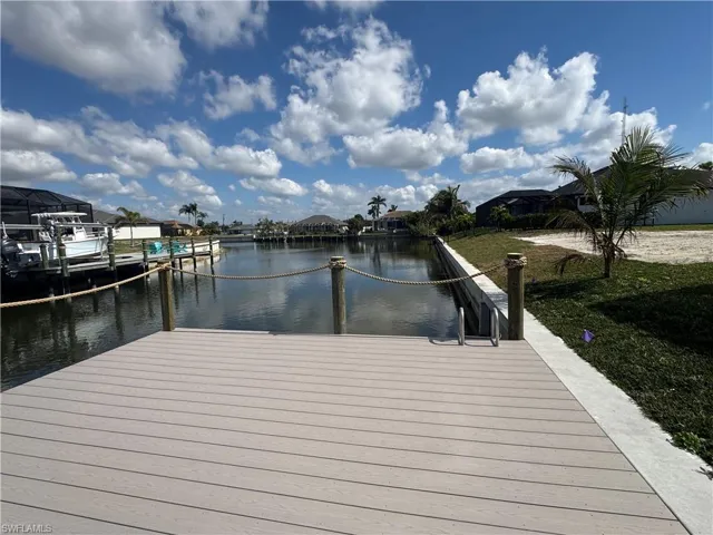 Dock area with a water view and a yard