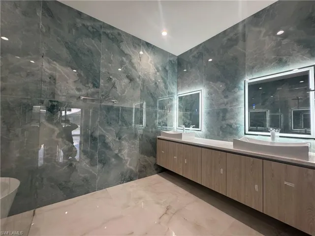 Bathroom with vanity and tile walls