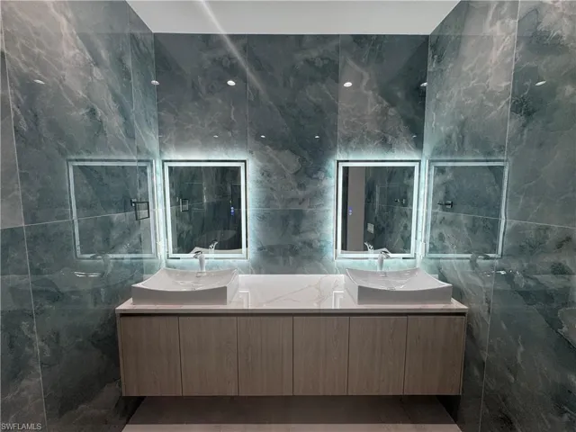 Bathroom with vanity and tile walls
