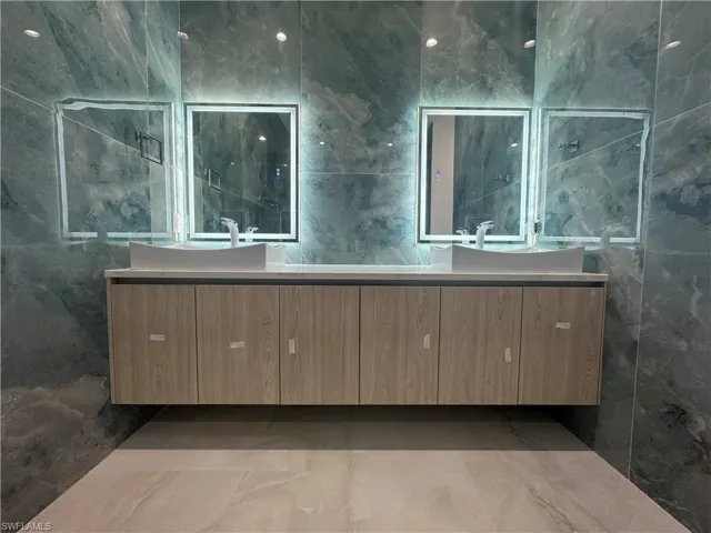 Bathroom featuring vanity and tile walls