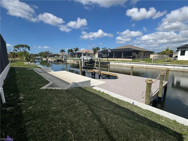 View of dock with a water view and a yard