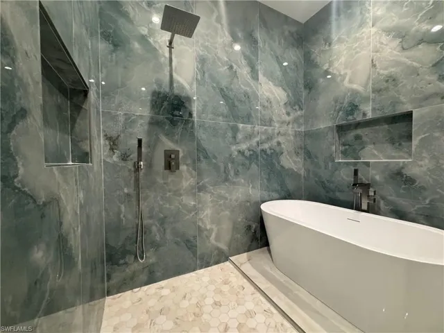 Bathroom featuring tile patterned flooring, shower with separate bathtub, and tile walls