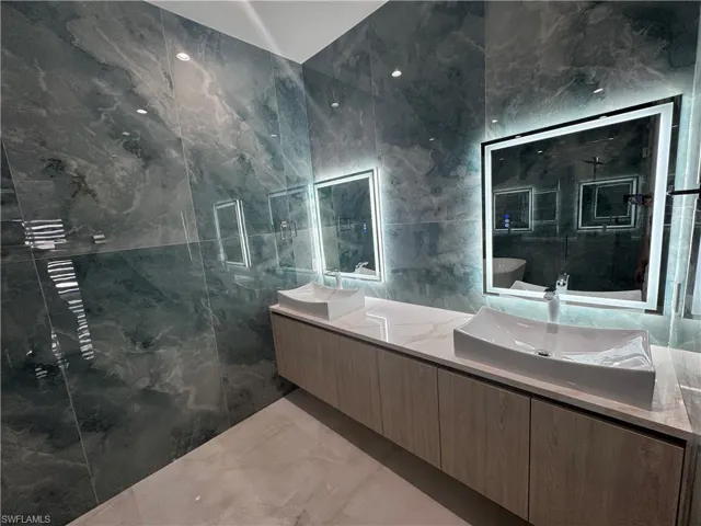 Bathroom featuring vanity and tile walls