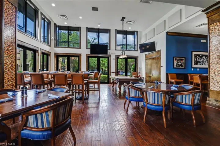 Dining space with a towering ceiling, hardwood / wood-style floors, billiards, and french doors