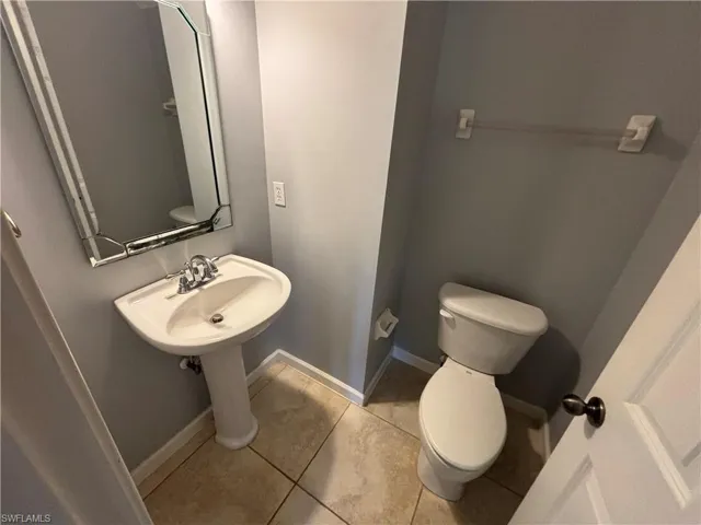 Bathroom with toilet and light tile patterned floors