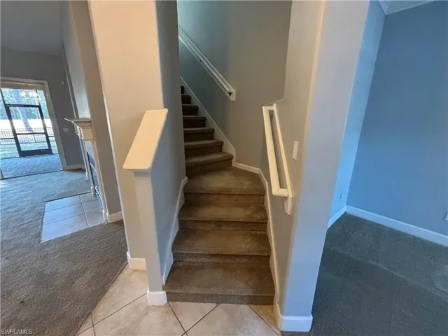 Stairway featuring carpet flooring and tile patterned floors