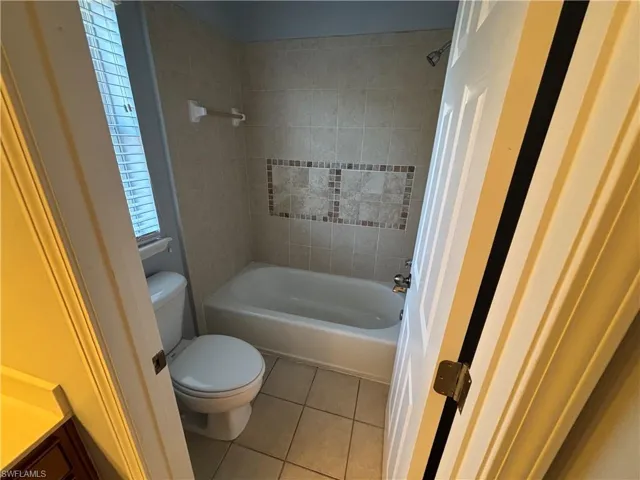 Bathroom featuring light tile patterned floors, bathtub / shower combination, and vanity