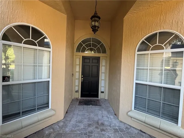 Entrance to property with stucco siding and a porch