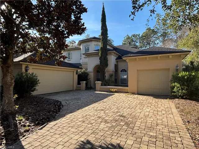 Mediterranean / spanish-style home with stucco siding, decorative driveway, a gate, and a garage