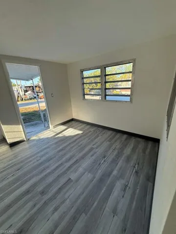 Unfurnished room with dark wood finished floors and baseboards
