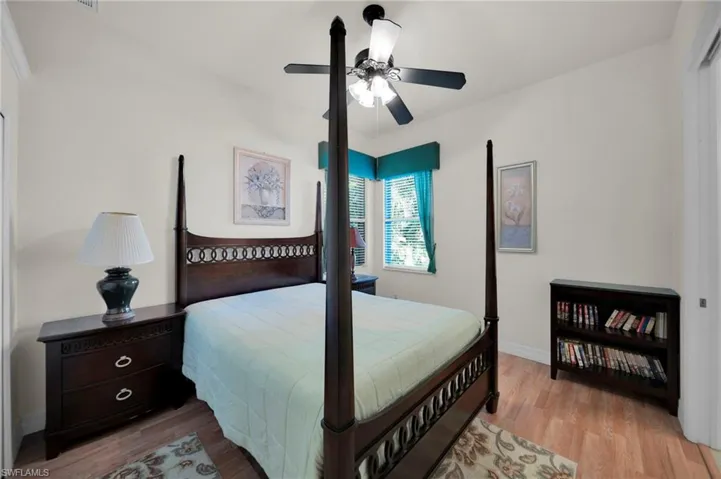 Bedroom with a ceiling fan, wood finished floors, and baseboards