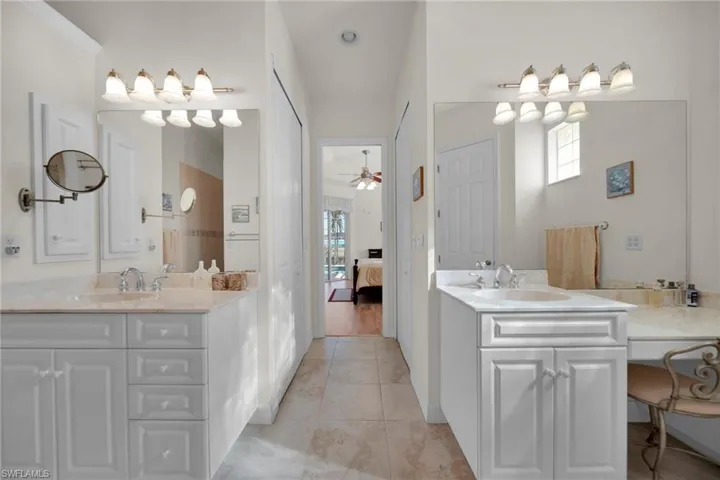 Full bathroom with tile patterned flooring, two vanities, and a sink