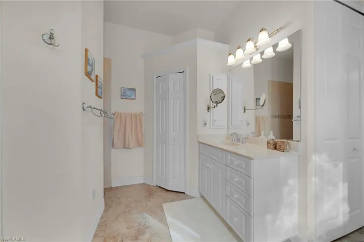 Full bath featuring vanity, tile patterned floors, baseboards, and a closet
