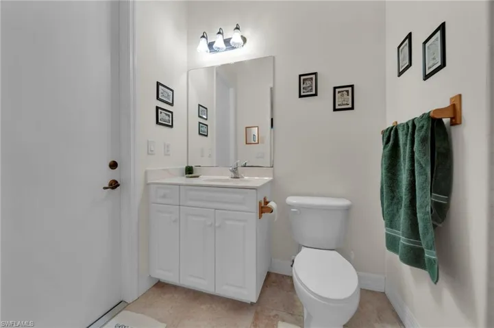 Bathroom featuring tile patterned flooring, toilet, vanity, and baseboards