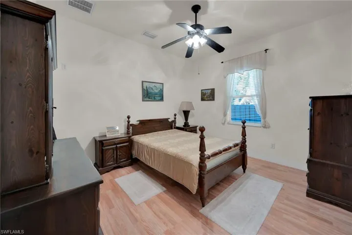 Living area with light tile patterned floors, high vaulted ceiling, and a ceiling fan