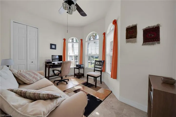 Office with light tile patterned floors, baseboards, and a ceiling fan