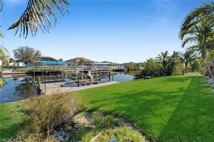 Dock area with a lawn, a water view, and boat lift