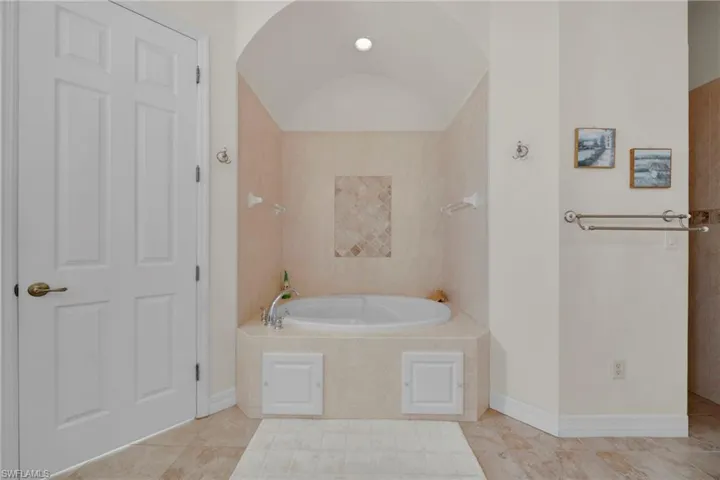 Bathroom featuring a bath, tile patterned flooring, and baseboards