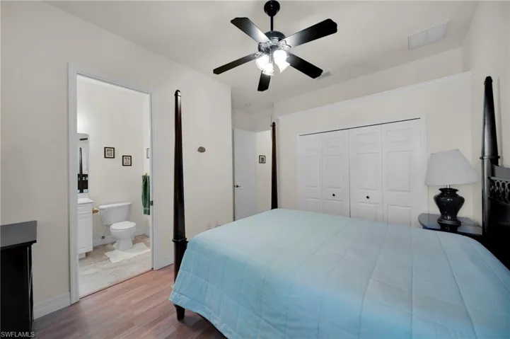Bedroom featuring visible vents, wood finished floors, a closet, baseboards, and ceiling fan