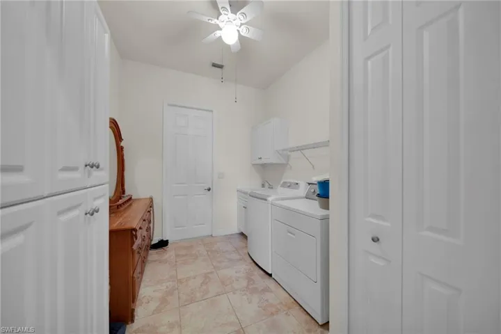 Laundry room featuring visible vents, light tile patterned flooring, cabinet space, ceiling fan, and washer and clothes dryer