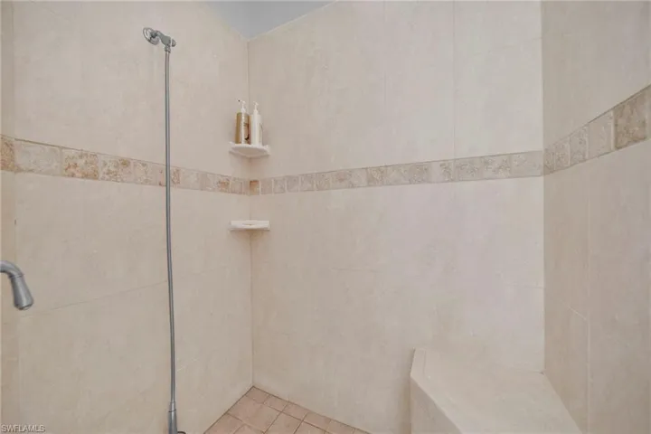 Bathroom featuring tile patterned flooring and a tile shower