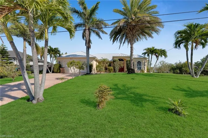 Mediterranean / spanish-style home with a garage, metal roof, concrete driveway, and a front yard