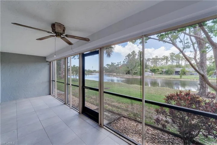 Unfurnished sunroom featuring plenty of natural light, ceiling fan, and a water view
