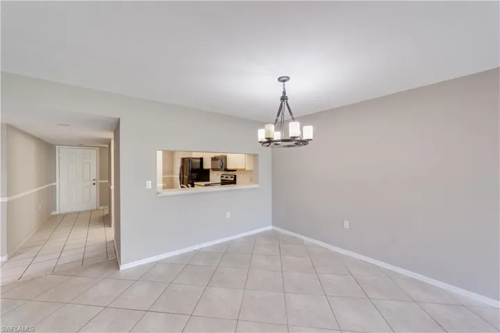 Unfurnished dining area featuring light tile flooring and an inviting chandelier