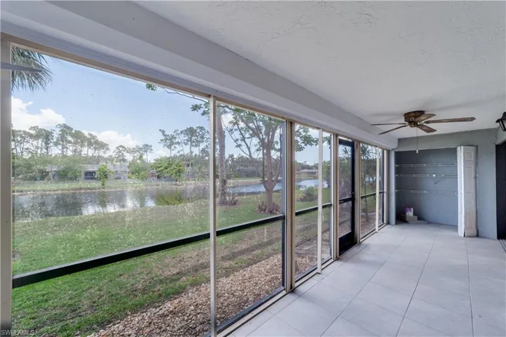 Unfurnished sunroom with ceiling fan and a water view