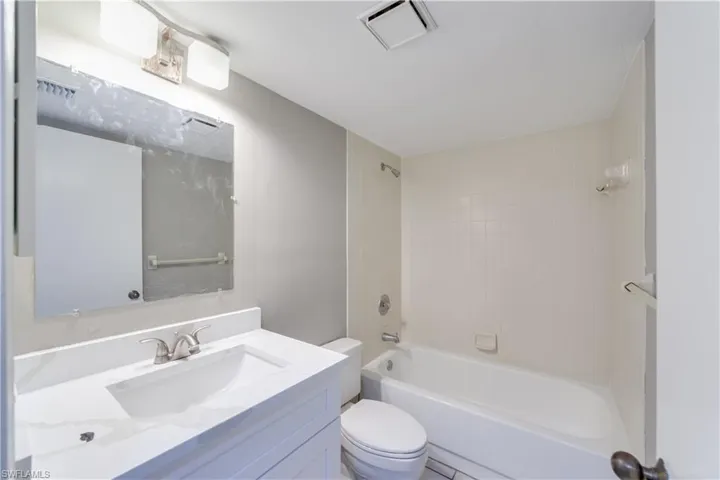 Full bathroom featuring vanity, toilet, and tiled shower / bath combo