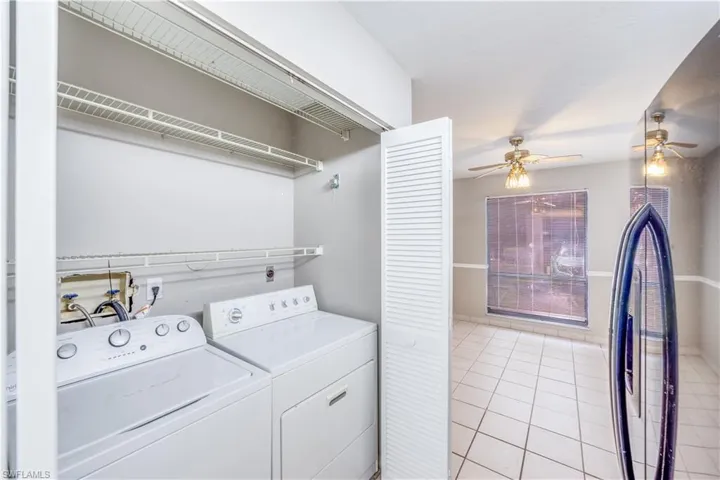 Laundry area with separate washer and dryer, ceiling fan, light tile floors, and hookup for a washing machine