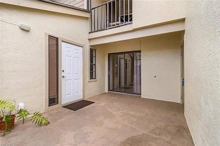 Doorway to property featuring a balcony, stucco siding, and a patio
