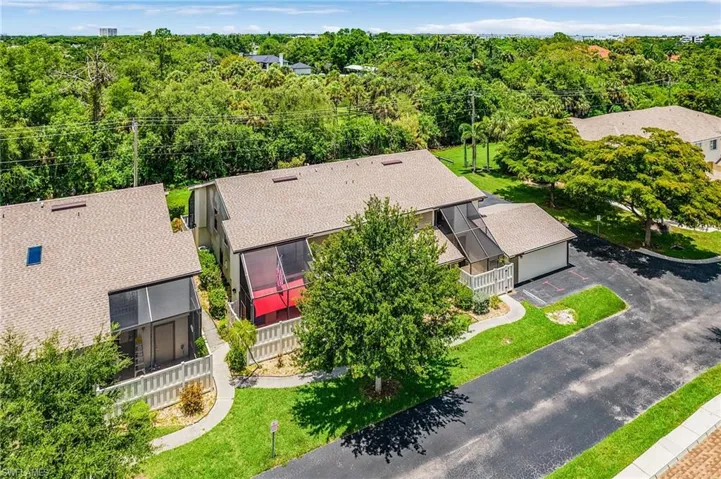 Aerial view of property and surrounding area featuring a heavily wooded area