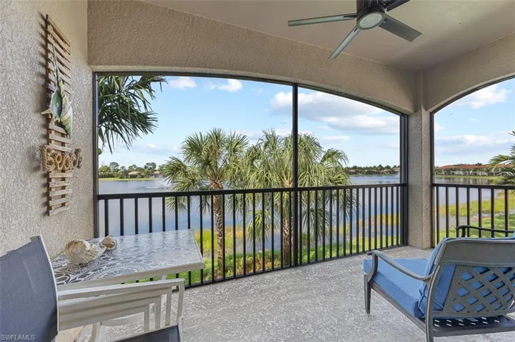 Sunroom / solarium featuring a water view and a ceiling fan