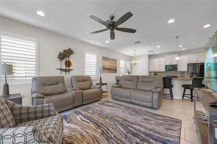 Living room with light tile patterned flooring, recessed lighting, visible vents, and ceiling fan
