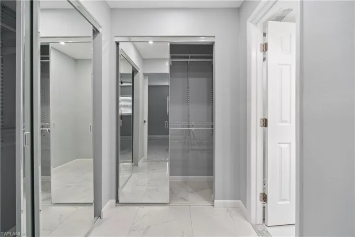 Walk in closet with light marble finish floors