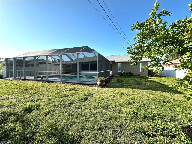 View of yard with fence, a fenced in pool, and a lanai