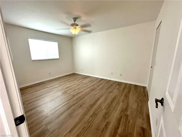 Unfurnished bedroom featuring wood finished floors, ceiling fan, and baseboards