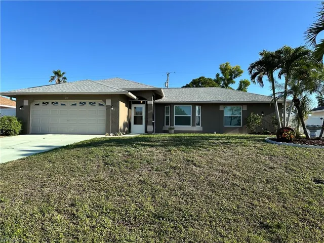 Single story home with concrete driveway, roof with shingles, stucco siding, a front lawn, and a garage