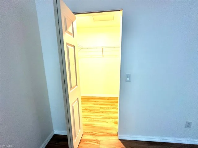 Corridor with wood finished floors and baseboards