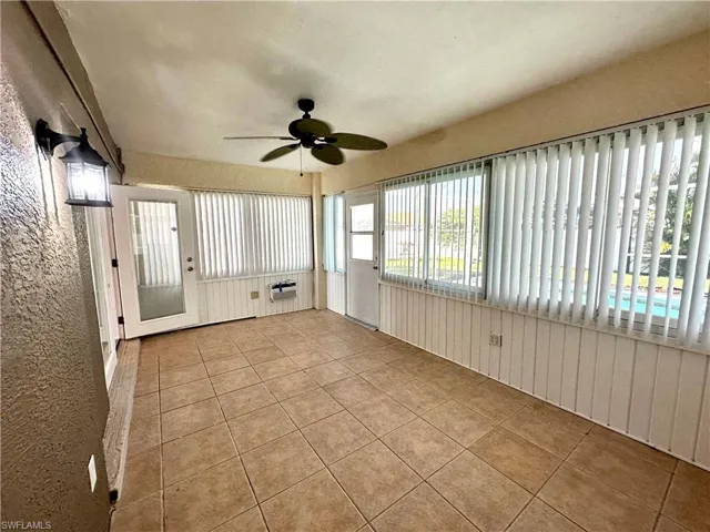 Unfurnished sunroom with ceiling fan