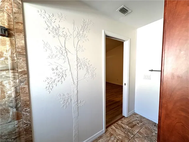 Hall with visible vents and baseboards