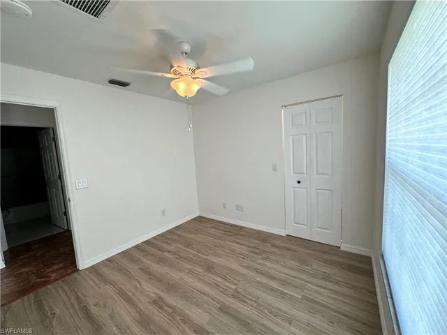 Unfurnished bedroom with visible vents, baseboards, and wood finished floors